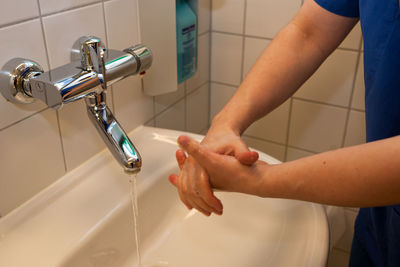 Midsection of woman in bathroom at home