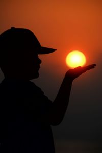 Rear view of man standing against sky during sunset