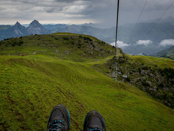 Low section of person on mountain against sky