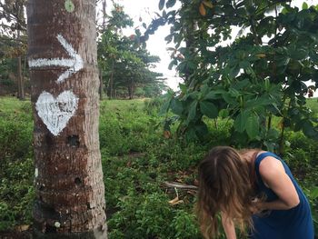 Rear view of woman standing against trees