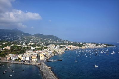 High angle view of city by sea against sky