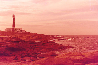 Scenic view of sea and buildings against sky during sunset