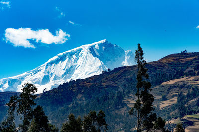 Scenic view of mountains against blue sky