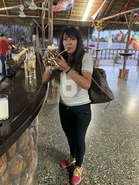 Portrait of a smiling young woman holding drink