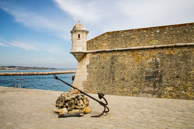 View of built structure by sea against sky