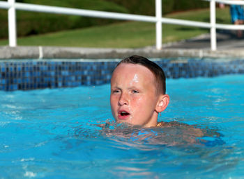 Portrait of shirtless boy swimming in pool