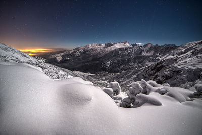 Scenic view of snowcapped mountains against sky at night