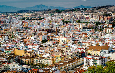 Cityscape by mountains against sky