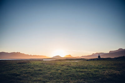 Scenic view of lake in front of mountains against clear sky