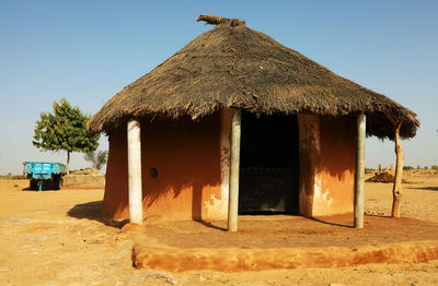 Traditional house at desert against clear sky