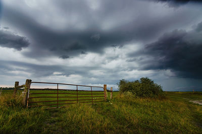 Fence on field against sky