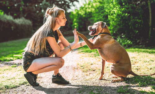 Full length of woman with dog sitting on plant