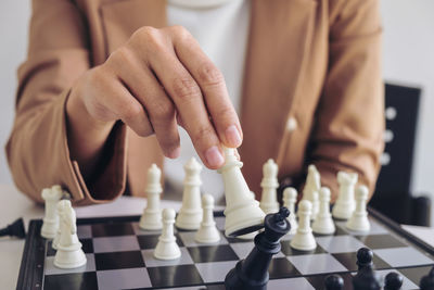 Midsection of businesswoman playing chess