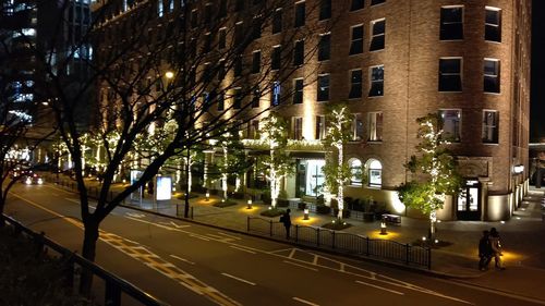 View of city street and buildings at night