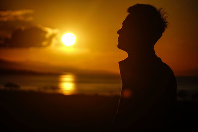 Silhouette man at beach during sunset