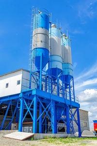 Industrial building with big blue tanks for cement, sand, water. 