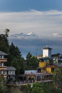 Houses by mountains against sky