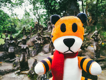 Close-up of stuffed toy against trees