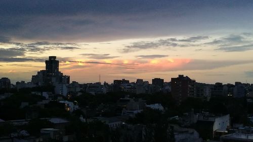 View of cityscape against cloudy sky during sunset