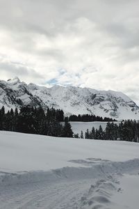 Scenic view of snow covered mountains against sky