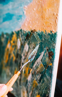 Close-up of person hand against sea