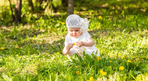 Portrait of young woman standing on grassy field