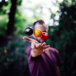 Man tossing billiard balls in air