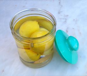 High angle view of lemons in container filled with water on marble