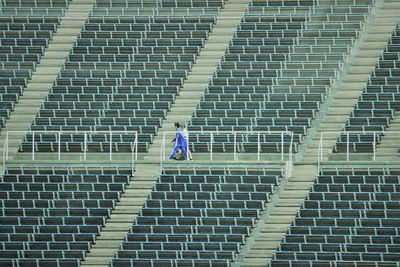 High angle view of 2 young people walking in empty stadium