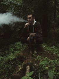 Woman with dog standing in forest