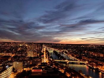 High angle view of city lit up at sunset