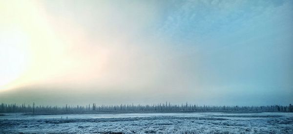 Scenic view of snow covered field against sky