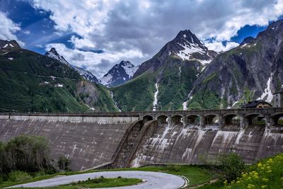 Scenic view of dam and mountains against sky