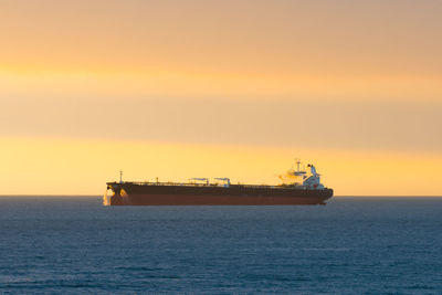 Cargo ship at sunset in the coasts of chile outside the port of valparaiso.