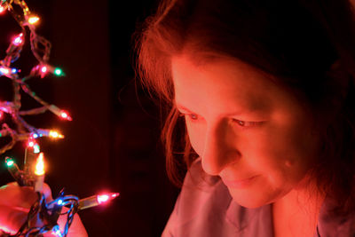 Portrait of woman with illuminated christmas lights