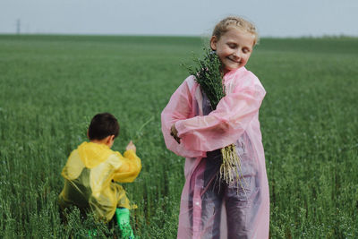 Happy girl playing on field against sky