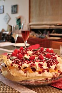 Close-up of fruit pavlova and wine served on table