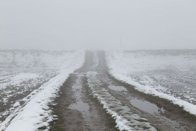 Scenic view of snow covered field against sky