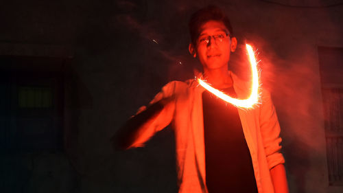 Portrait of man standing by light painting at night