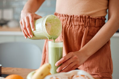 Midsection of woman holding bottle