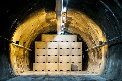 Stack of crates in illuminated tunnel