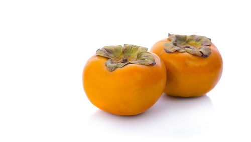 Close-up of orange fruit against white background