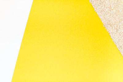 High angle view of yellow paper against white background