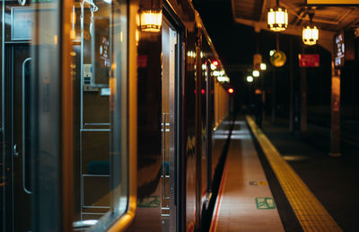 Train at illuminated railroad station at night