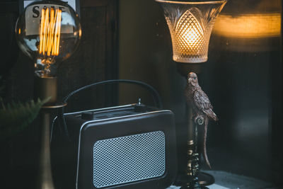 Close-up of illuminated electric lamp on table