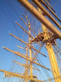 Low angle view of sailboat against clear blue sky