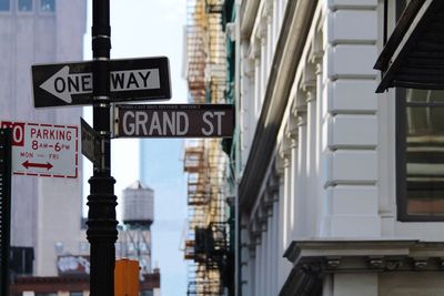 Close-up of road sign against buildings in city