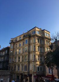 Low angle view of buildings against clear blue sky