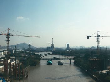 View of bridge in city against cloudy sky