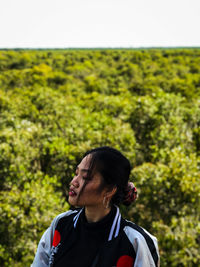 Young woman against trees